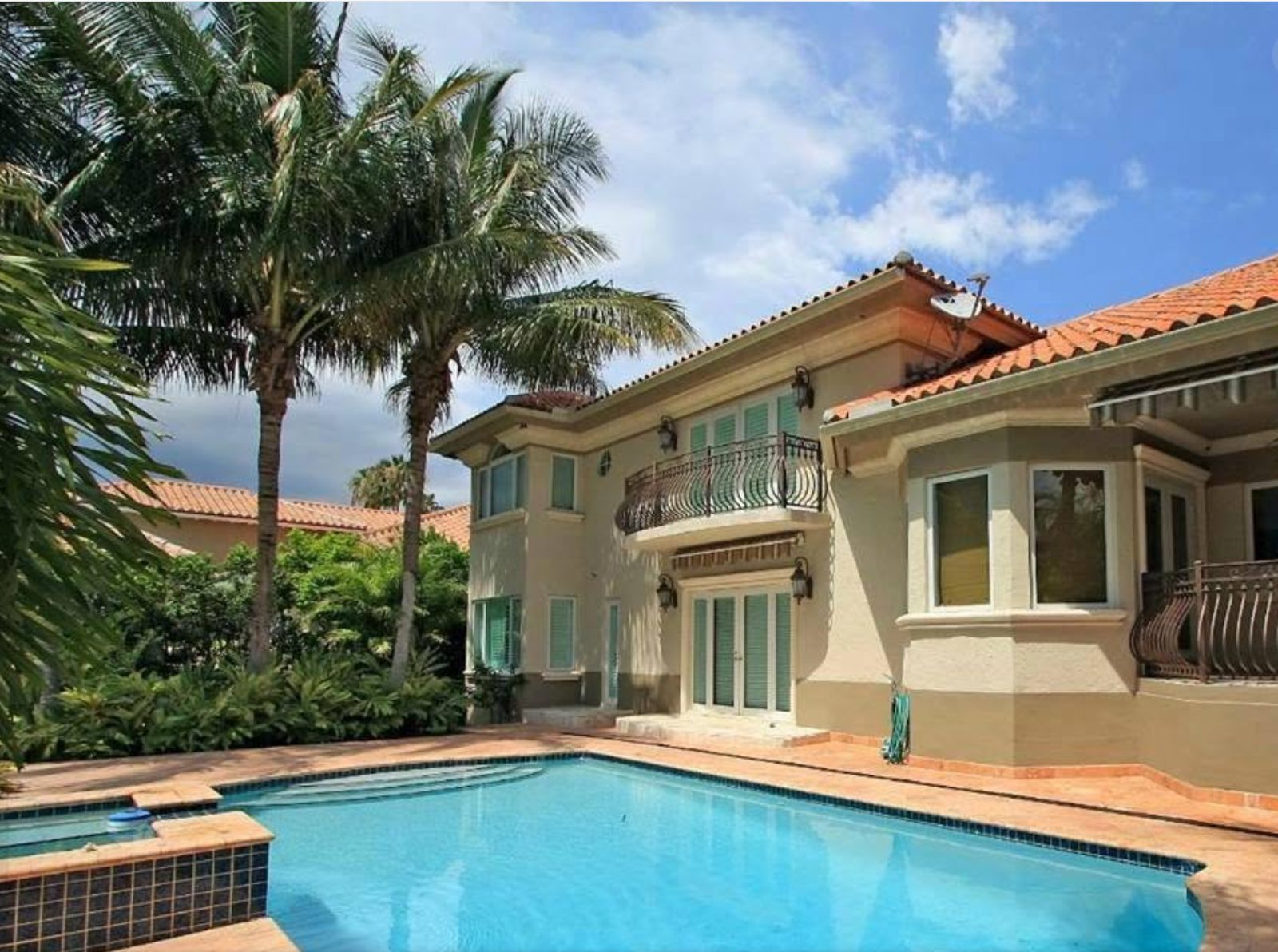 Large home with terracotta roof overlooking a clear blue pool ready for listing photos
